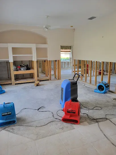 Air movers and a dehumidifier running on a bare slab in a Charlotte County home