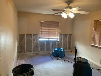 Flood-cut room with an air mover and dehumidifier set up during a Punta Gorda dry-out